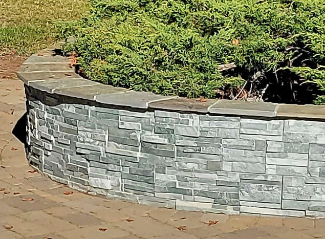Ledge stone veneer seatwall with flagstone cap.