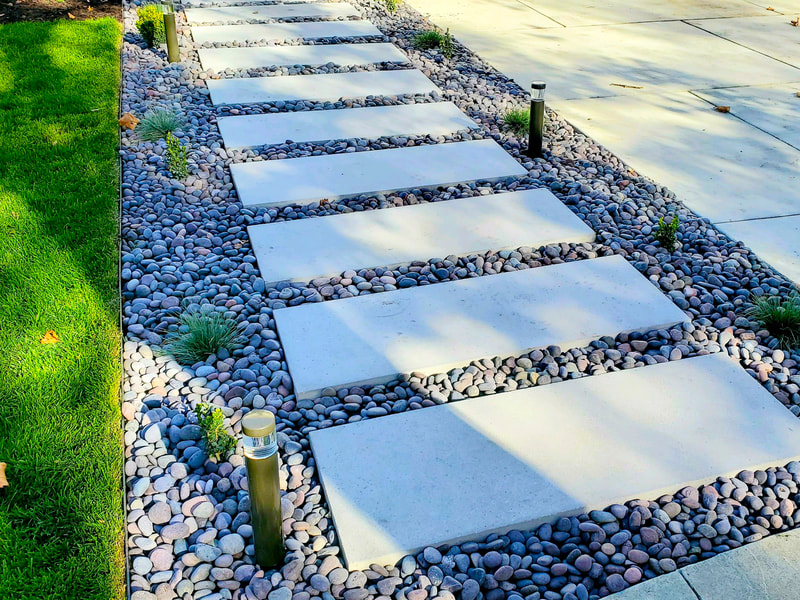 Pre-cast stepstones entry walkway with lapaz stones, low volt lighting and plants.