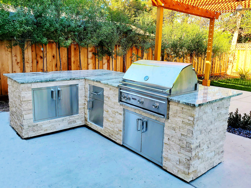 Custom outdoor kitchen with granite countertop and ledge stone veneer.